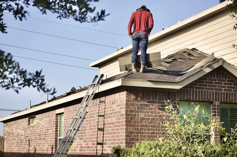 Professional roofer working on a residential roof in Farmington Glen